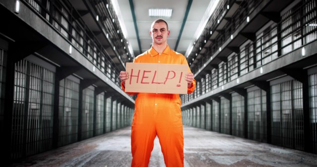 Prisoner holding a sign that says Help