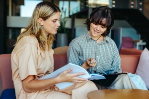 Two women sitting together reviewing paperwork