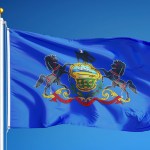 Pennsylvania state flag flying against a blue background