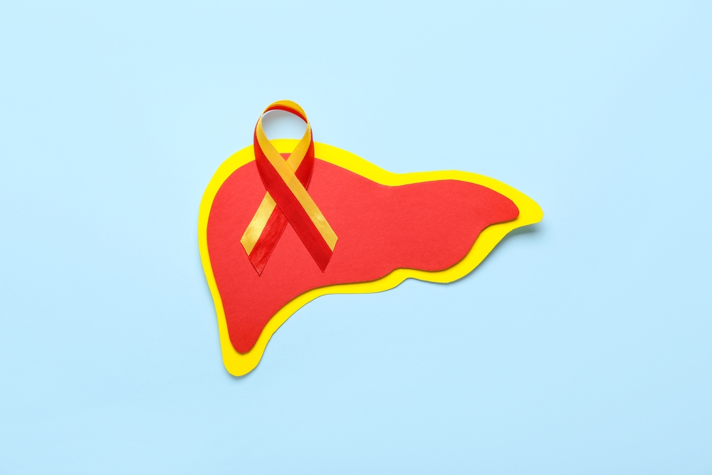 Awareness ribbon with paper liver on blue background. Hepatitis concept